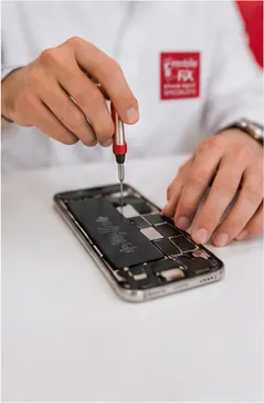 Close-up of a phone being opened with a precision screwdriver