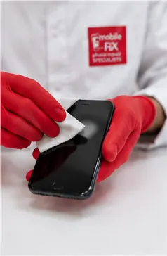 Technician cleaning a repaired phone before handback